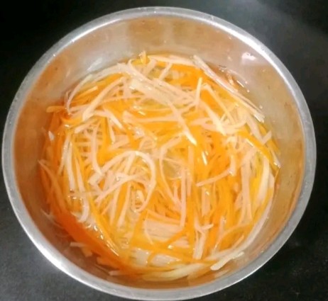 凉拌土豆胡萝卜丝,起锅烧水,水开放入土豆胡萝卜丝焯水,捞出放入凉开水中浸泡