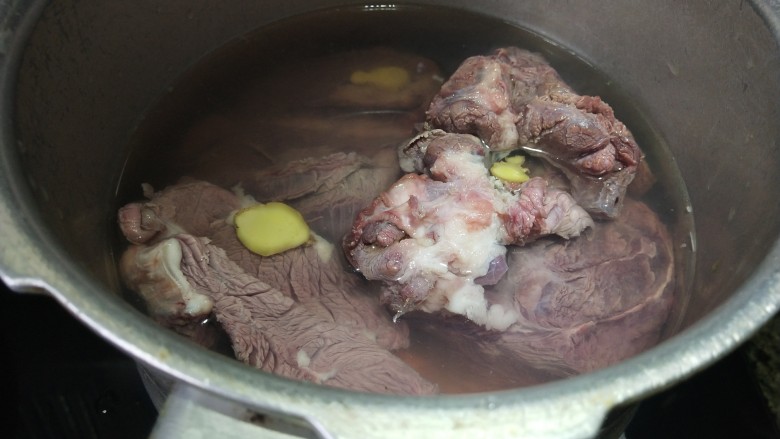 卤牛肉,把牛肉块放入锅里,加点料酒和姜片,倒入开水