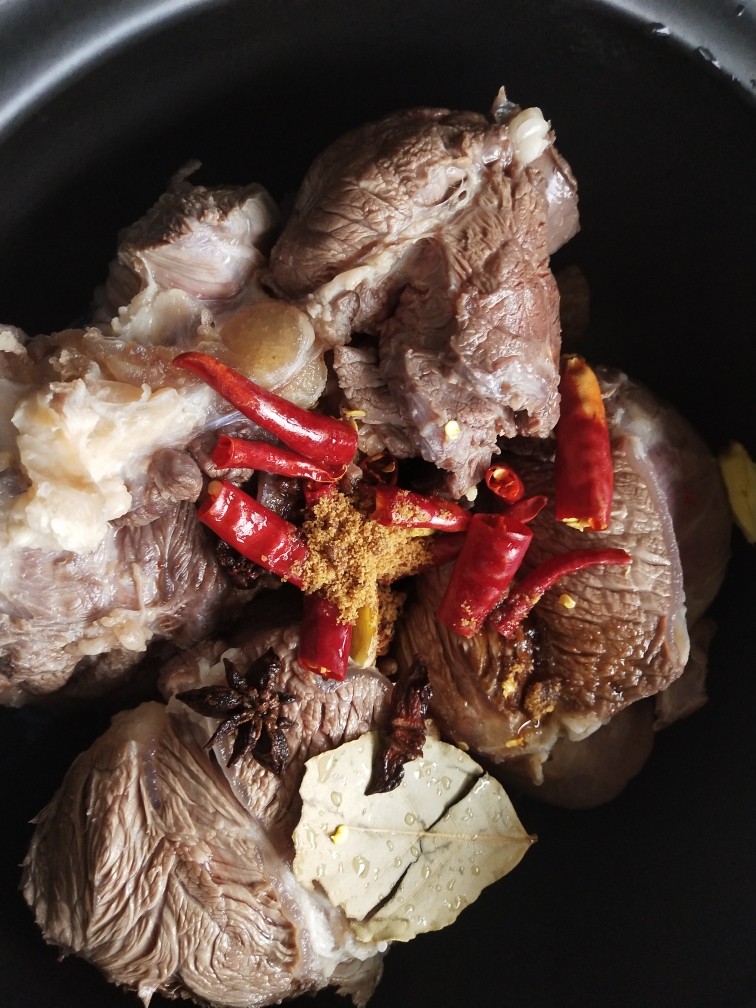 卤牛肉,倒掉焯牛肉的水,洗干净,放入红糖,香料,料酒和干红辣椒