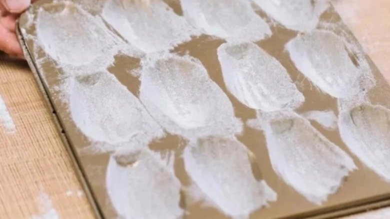 零失败,入门级甜点玛德琳做法,将模具抖一抖,除去多余的面粉,这样就做好模具的防粘处理。