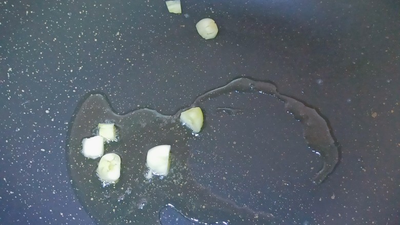 青椒炒花菜,锅内加入适量食用油,加入蒜瓣爆香