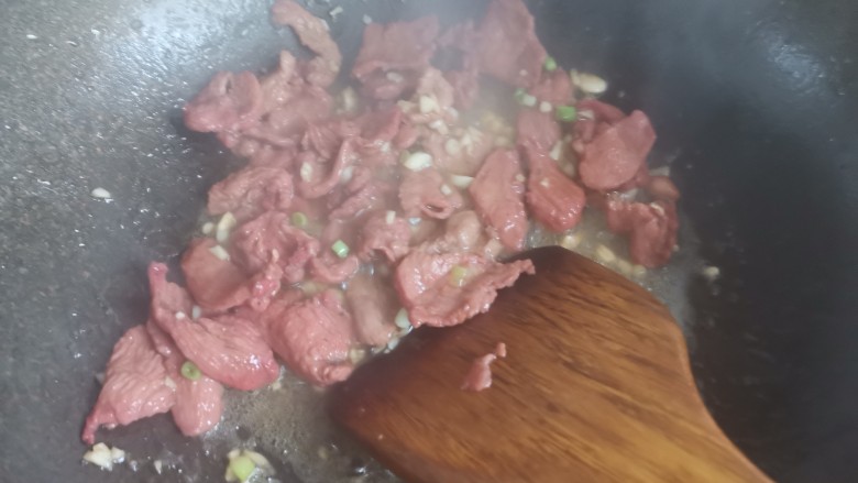 滑蛋牛肉,下入蒜末,葱白翻炒出香味