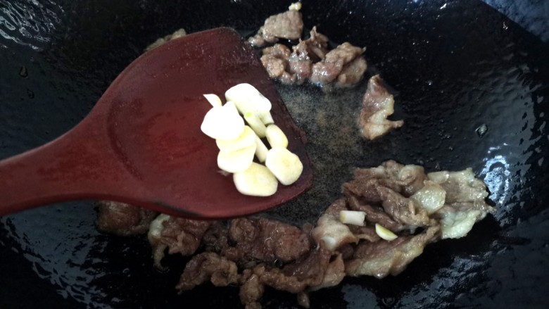 茭白烧肉,肉炒至变色,放入蒜片炒出香味