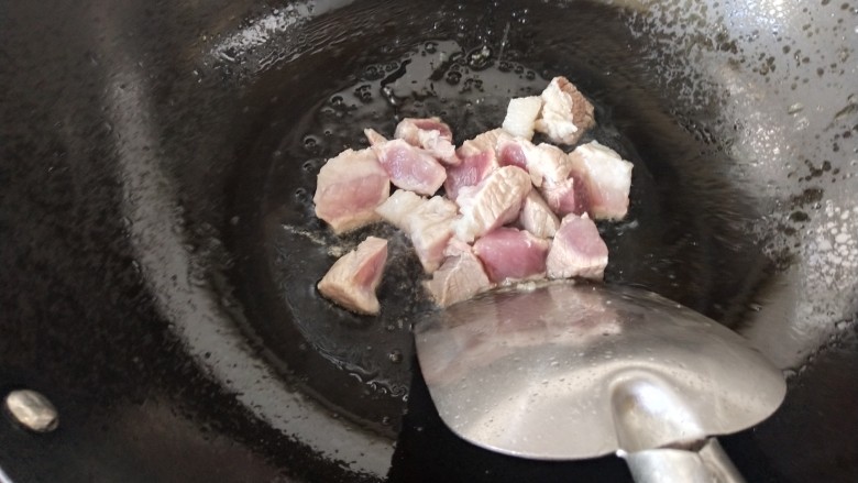 白萝卜炖猪肉,锅里的冰糖融化后,看上去有点焦黄时倒入猪肉块煸炒,炒制变色