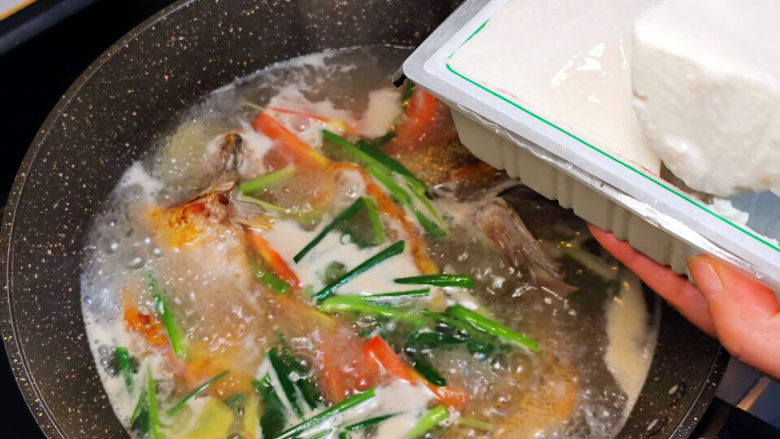 鲈鱼炖豆腐,煮开后,将豆腐挖入鱼锅中
