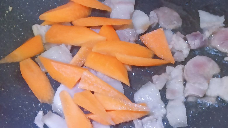 茭白烧肉,猪肉翻炒至变色后,逼出肥肉里的油,再加上胡萝卜翻炒