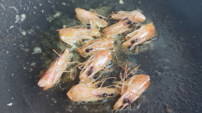 玉米虾仁蛋炒饭,锅烧油下入虾头,煸出虾头油,盛出备用