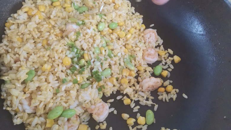 玉米虾仁蛋炒饭,撒上葱花,翻炒均匀即可出锅
