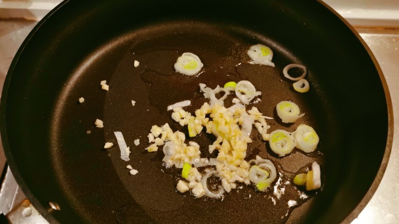 黄瓜炒土豆丝,起油锅放入食用油,油热后放入蒜碎、葱片翻炒出香味。