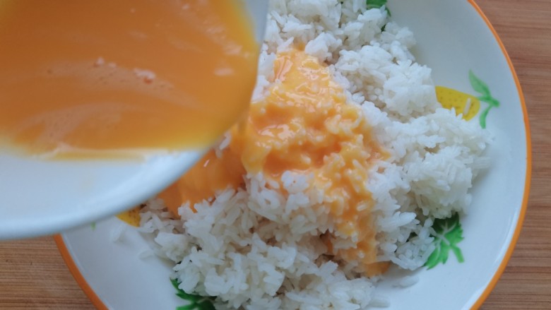 玉米虾仁蛋炒饭,蛋黄液倒入<a style='color:red;display:inline-block;' href='/shicai/ 507'>米饭</a>抓匀