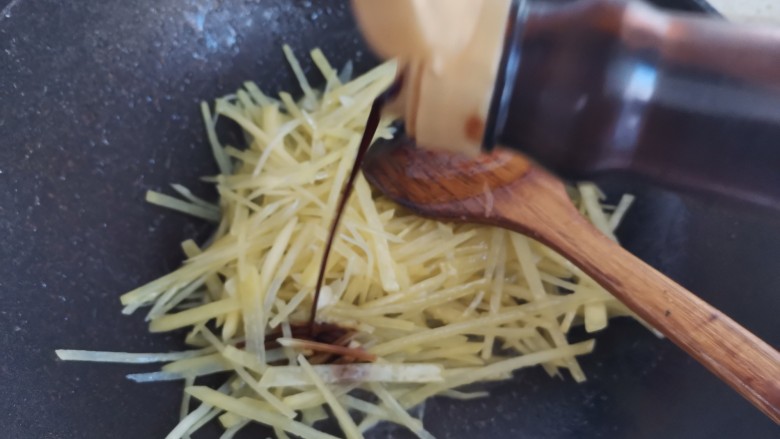 黄瓜炒土豆丝,加入一勺生抽,翻炒均匀
