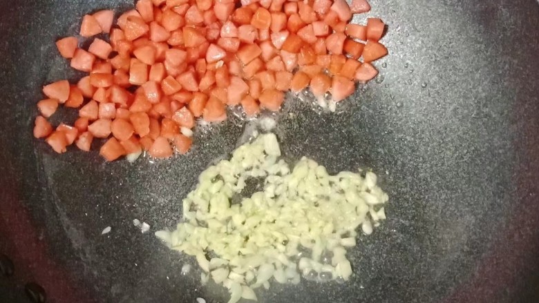 小炒毛豆,把火腿挪到一边,放入蒜末爆香