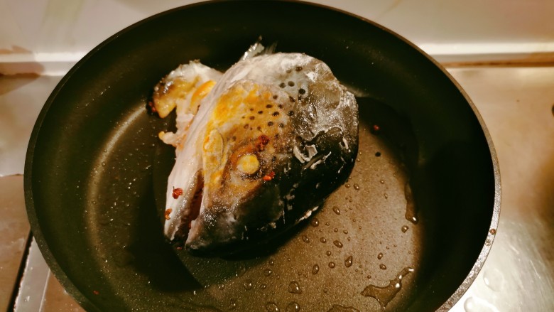 鱼头炖汤,起油锅放入2汤匙食用油,油热后放入鱼头煎至两面微微焦黄色。