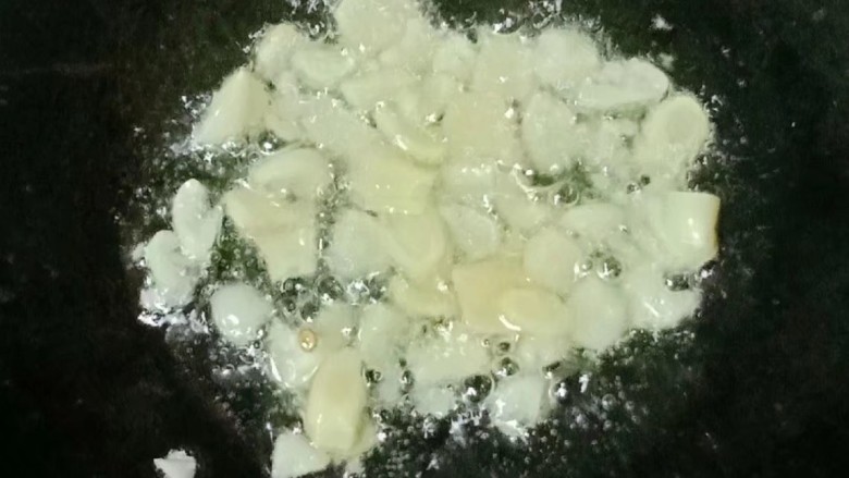 酸豆角炒鸭肾,热锅下油,放入姜片和大蒜爆香