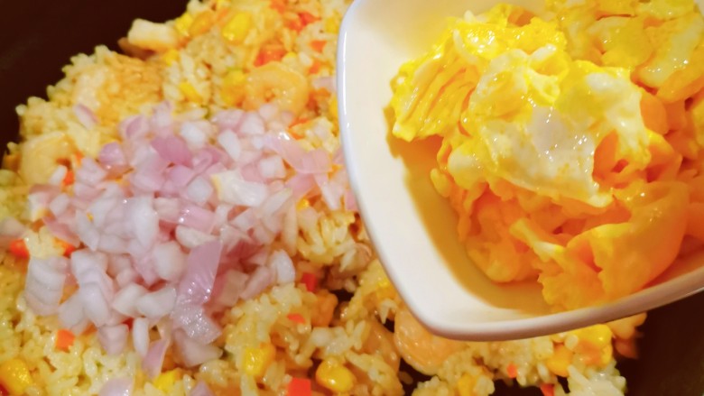 玉米虾仁蛋炒饭,米饭炒散后,放入迷你小洋葱增加香气,放入之前炒好的鸡蛋。