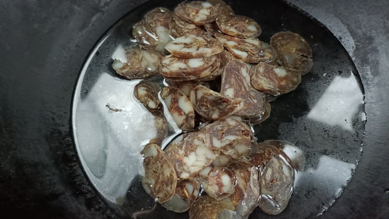 豆米炒腊肠,另起锅烧水,倒入腊肠