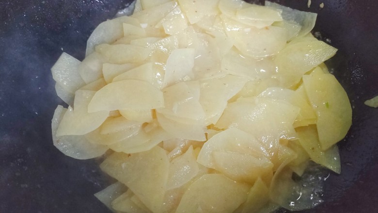 土豆回锅肉,加入土豆片,不停翻炒至土豆片呈半透明状