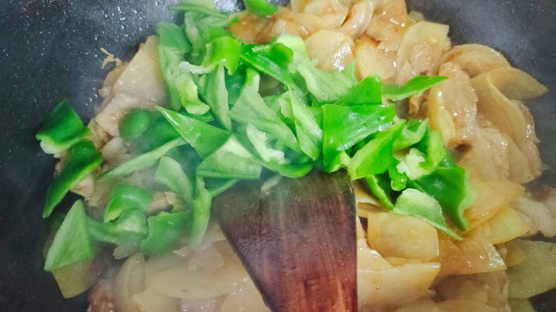 土豆回锅肉,加入青椒,不停翻炒至青椒断生