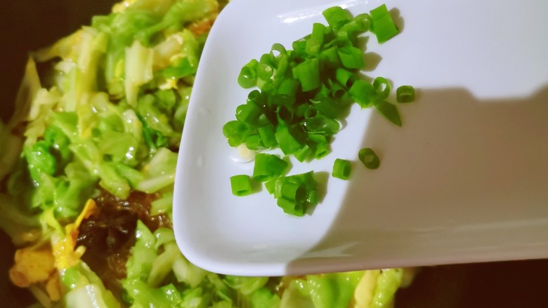 包菜粉丝炒鸡蛋,放入香葱碎增香,关火出锅。