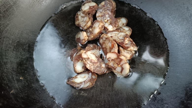 腊肠炒饭,起锅烧水,倒入香肠,烧开捞出备用