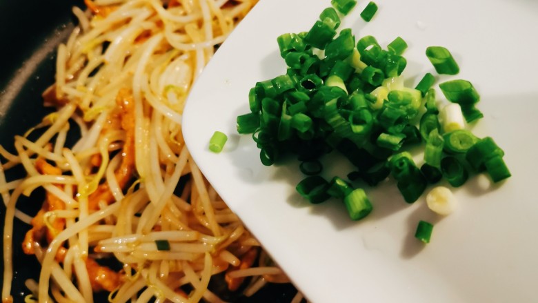 豆芽炒肉丝,撒上香葱碎,关火出锅。
