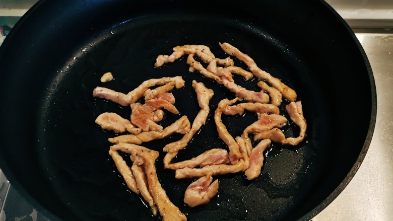 豆芽炒肉丝,起油锅放入食用油,油热后放入肉丝翻炒变色。