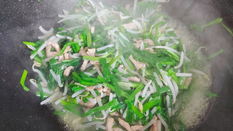 豆芽炒肉丝,翻炒至豆芽和韭菜变软,体积变小