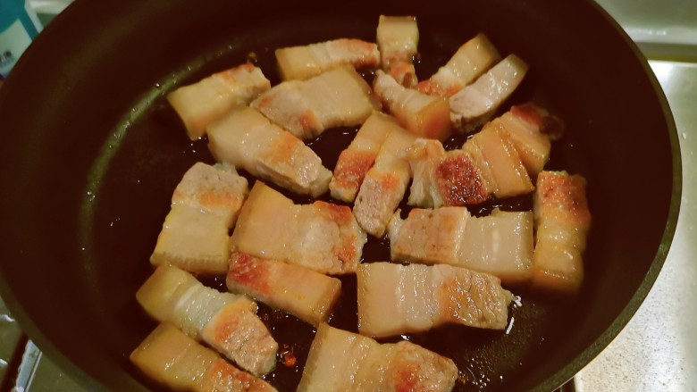 红烧猪肥肉,煎至两面有微微焦黄色并煎出许多油脂,出锅备用。