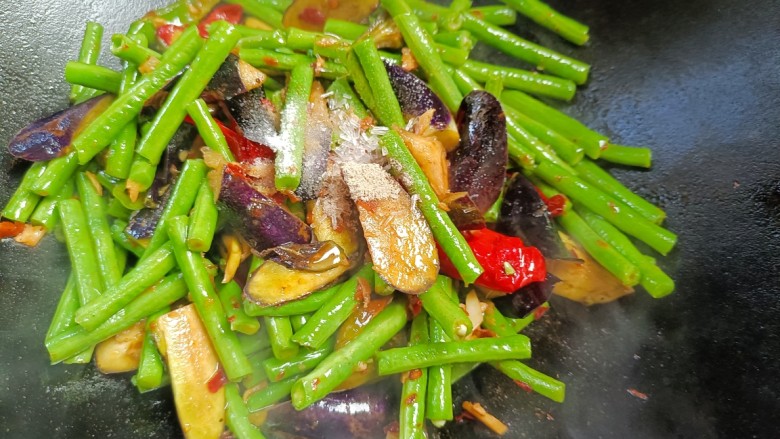 茄子烧豆角,放入胡椒味精,食盐炒匀烧熟