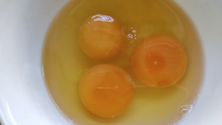 包菜粉丝炒鸡蛋,鸡蛋磕入碗中,加盐和少许料酒