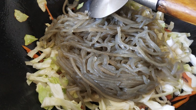 包菜粉丝炒鸡蛋,倒入粉条,加入盐,炒匀