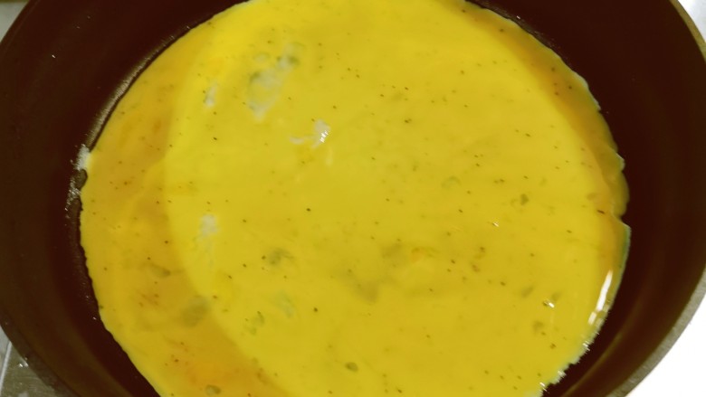 秋葵鸡蛋卷,起油锅,薄薄地刷一层食用油,倒入鸡蛋液。