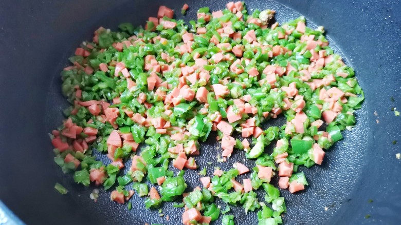 青椒火腿鸡蛋饼,青椒、火腿丁放入锅中炒至断生盛出,