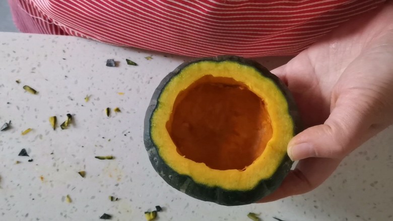 万圣节南瓜虾仁炒饭,南瓜切去头部,用勺子挖干净南瓜瓤