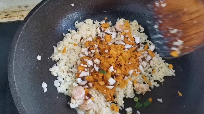万圣节南瓜虾仁炒饭,再倒入香菇碎和南瓜岁,翻炒均匀