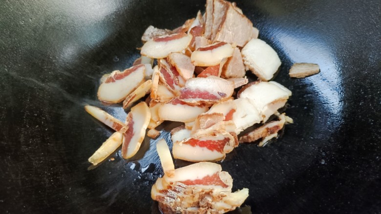 回锅肉炒萝卜,起锅放入回锅肉,小火炸香,炸出油