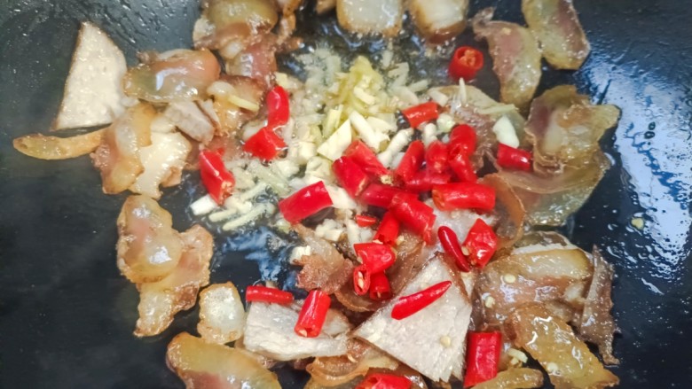 回锅肉炒萝卜,放入料酒,生姜大蒜,辣椒炸香