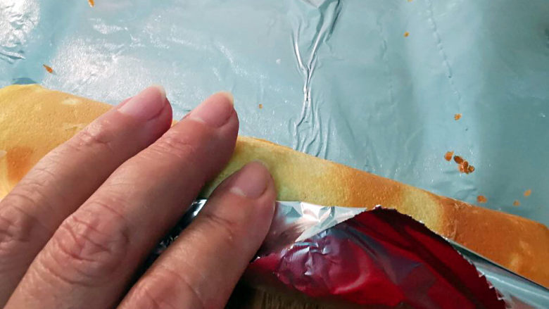 煎蛋糕卷,重新卷好蛋卷,用锡纸包好