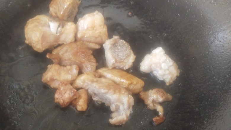 排骨土豆炖豆角,冰糖融化后,放入排骨翻炒均匀