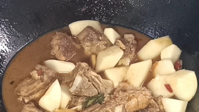 萝卜烧排骨,揭盖,倒入萝卜,加少许盐,胡椒味精拌匀,继续烧至萝卜熟烂