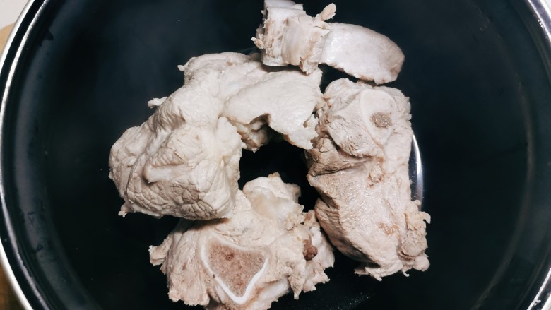 排骨土豆炖豆角,压力锅内胆底部铺上姜片,码放焯水后的排骨。