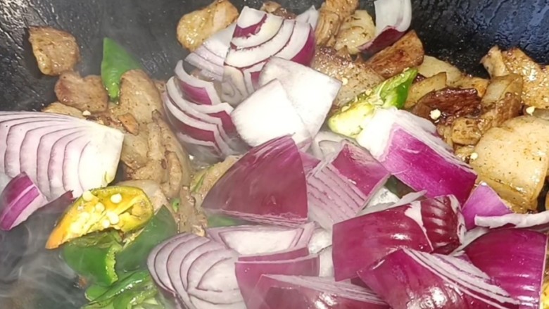 排骨土豆炖豆角洋葱炒五花,放入洋葱炒匀