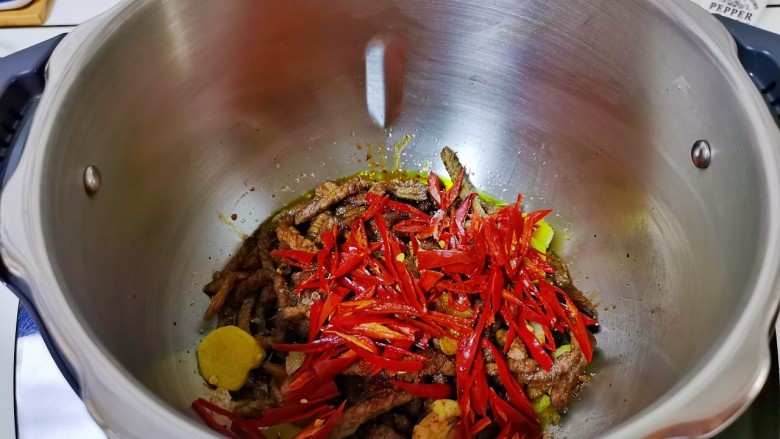 青椒爆炒牛里脊,加入辣椒丝,盖上盖子翻炒3分钟。