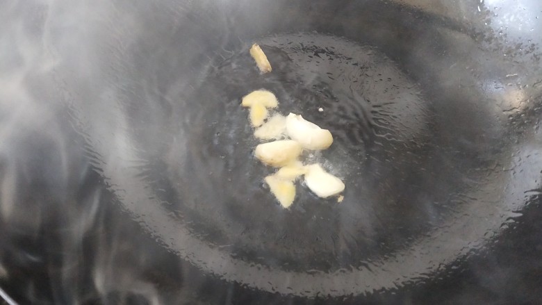 蘑菇炒肉片,锅里放油烧热,把蒜瓣和姜片放进去炒出香味