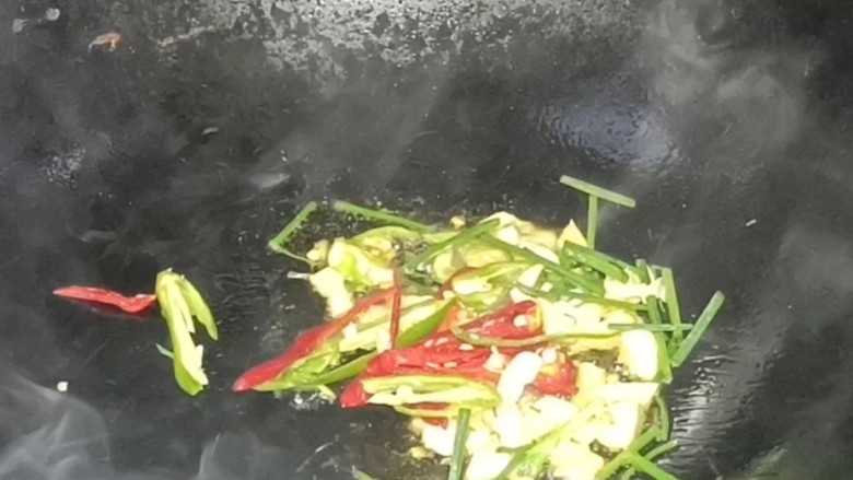 酸辣土豆丝,起锅烧油,放入葱蒜和青红辣椒,炒香至出辣味
