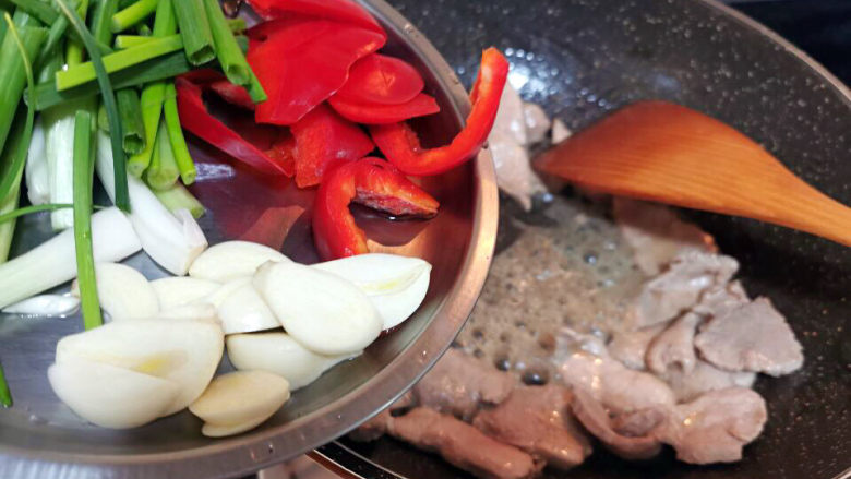 蘑菇炒肉片,肉片变色后,加入葱蒜爆香