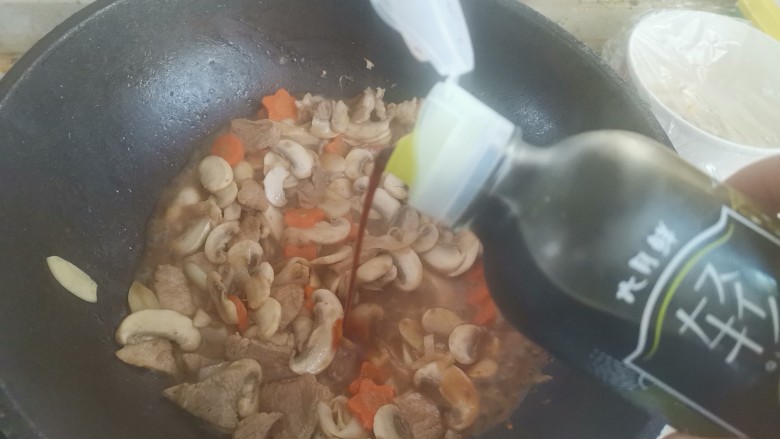 蘑菇炒肉片,加入一勺生抽,翻炒均匀