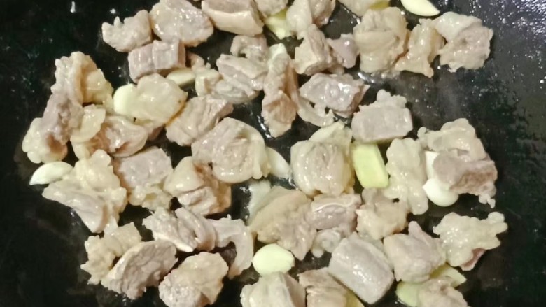 红焖牛肉煲,热锅下油,放入姜蒜爆香,倒入牛肉翻炒