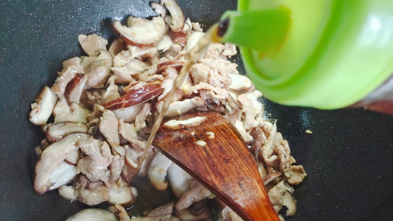 蘑菇炒肉片,加适量料酒,翻炒均匀
