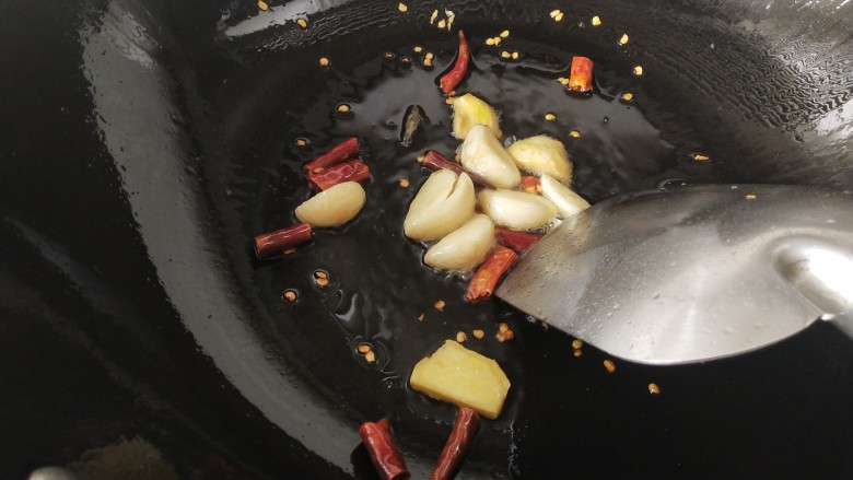 酸菜海鲜锅,锅里放油烧热,放入姜蒜干红辣椒煸炒,炒出香味
